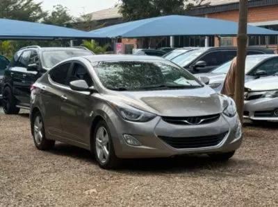 Affordable silver compact sedan parked in a used car dealership, representing budget-friendly cars for first-time drivers in Nigeria.