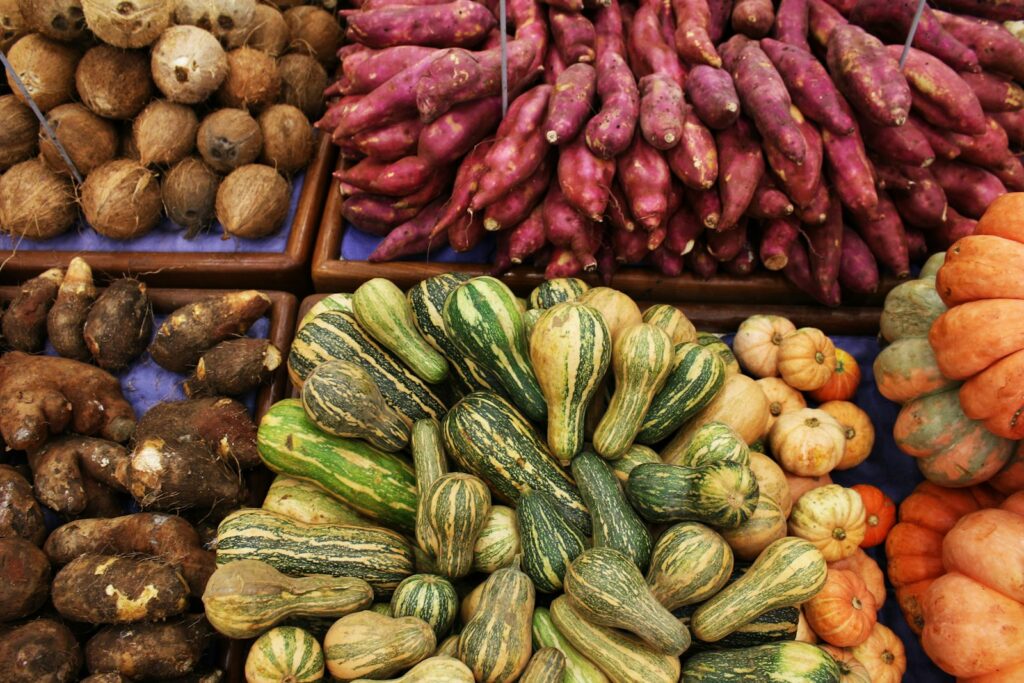 A variety of fresh vegetables and gourds on display at a market