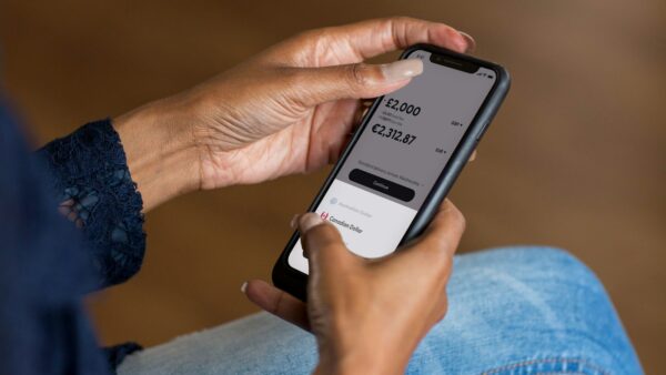 Hands holding a smartphone with a money transfer app open