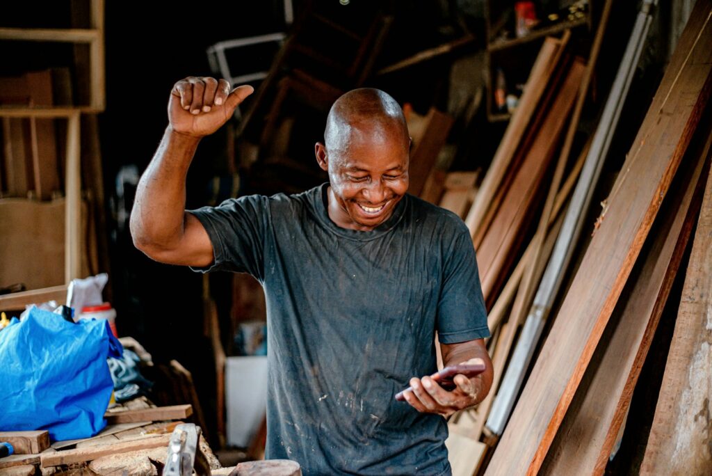 A man smiling while looking at his mobile phone