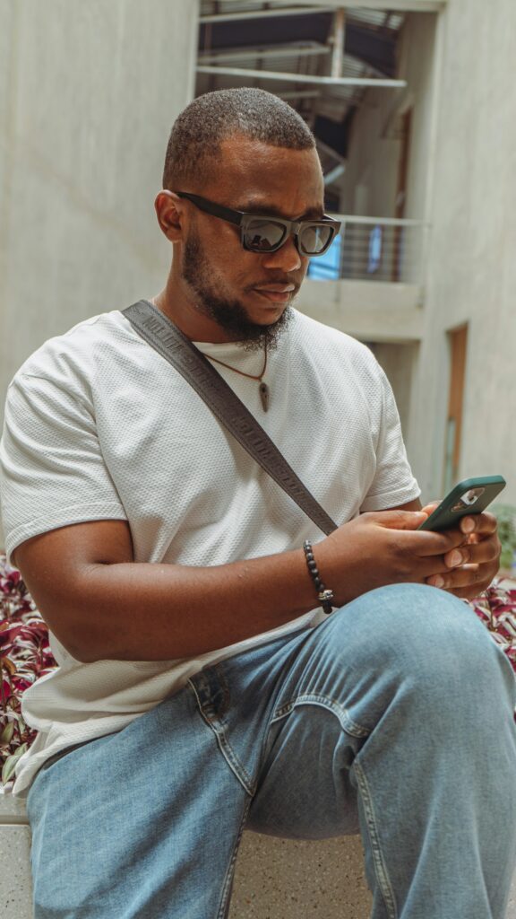A man sitting on a bench looking at his phone