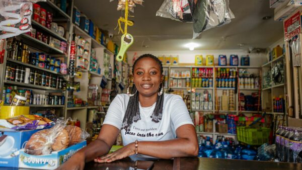 A woman sitting at the counter of a small shop