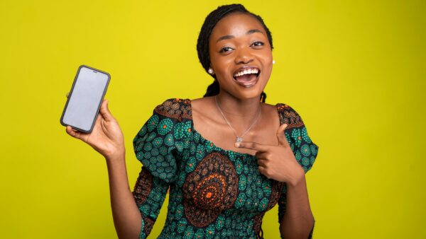 A woman in a green dress holding a mobile phone